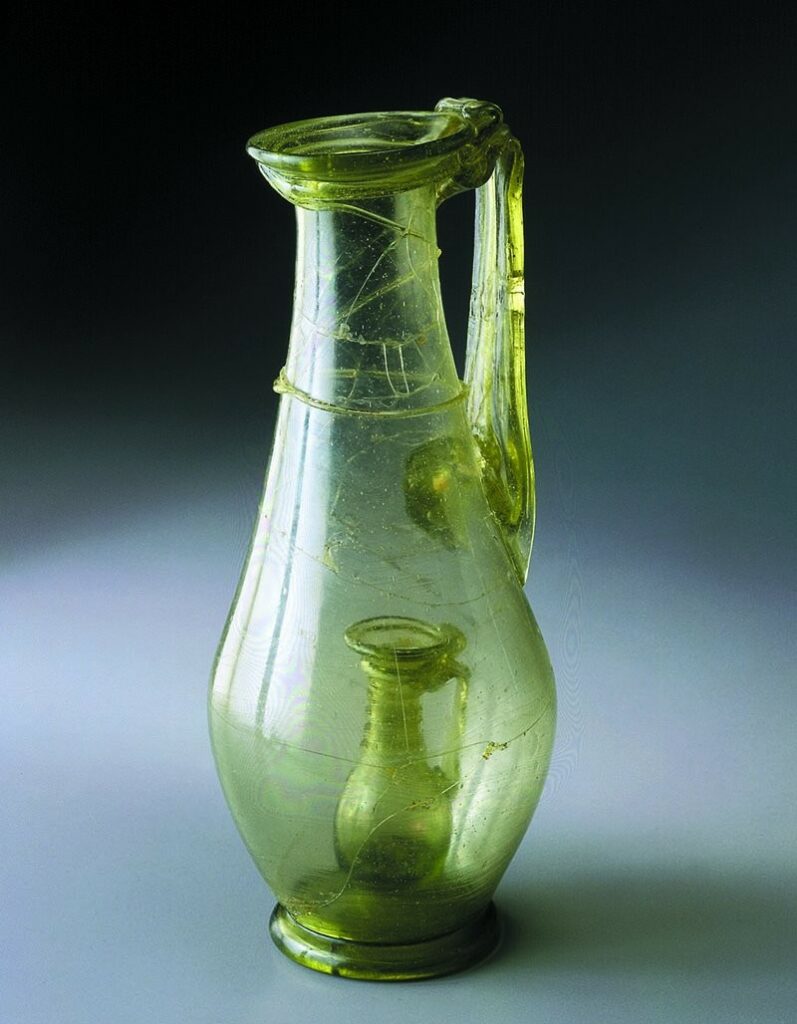 l'eau est plus fraîche dans la cruche intérieure. Roman glass jug with a smaller glass jug inside – a so-called joke-jar that shows the skill of the glassmaker. Probably made in workshop in Cologne, found in burial in Stein am Rhein, Switzerland, 4th c. AD. Photo : Kantonsarchäologie Schaffhausen / Rolf Wessendorf